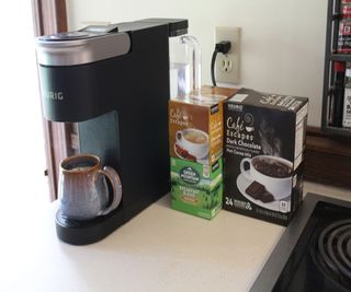 Making coffee with the Keurig K-Supreme SMART Coffee Maker, next to various K-Cups
