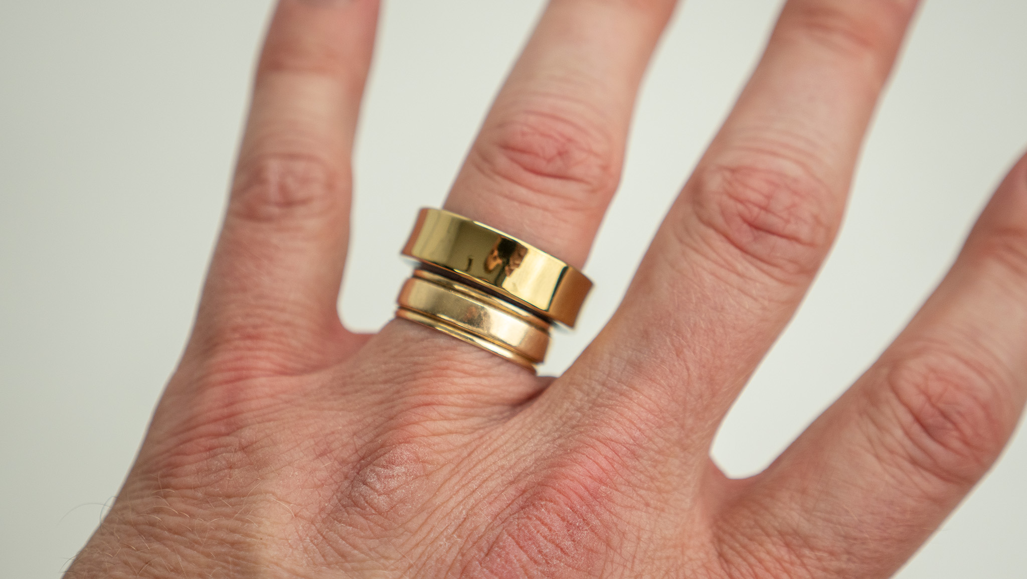 Comparing the gold Samsung Galaxy Ring with a gold wedding band