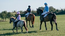 Three horse riders of different ages wearing body protectors