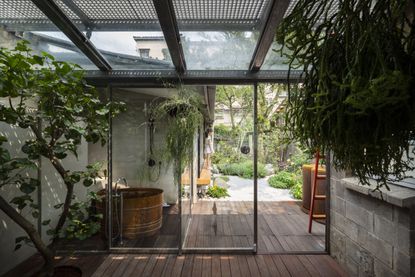 Indoor Japanese garden with a soaking tub and trees and hanging plants