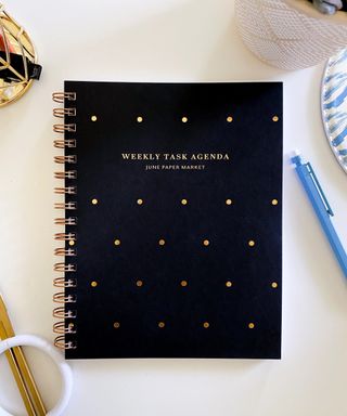Weekly planner in dark finish with gold dots.