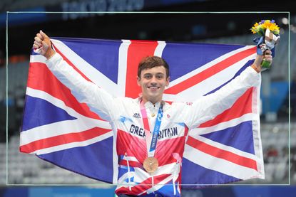 Tom Daley poses with a Union Jack and his medal after winning bronze at the Tokyo 2020 Olympics