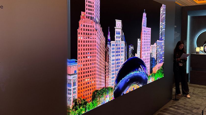 Samsung's 140-inch micro-LED at CES 2026. showing the screen on the side of the TV panel as well as the front TV panel. An image of buildings in a city is on the screen, and one building can be seen on both the side and the front