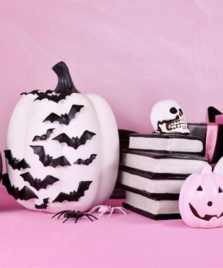 black and white pumpkins on a pink background
