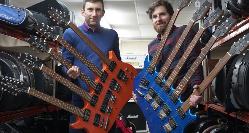 Joby Hobbs and Luke Hobbs of Gardiner Houlgate with two five-necked Hutchins guitars