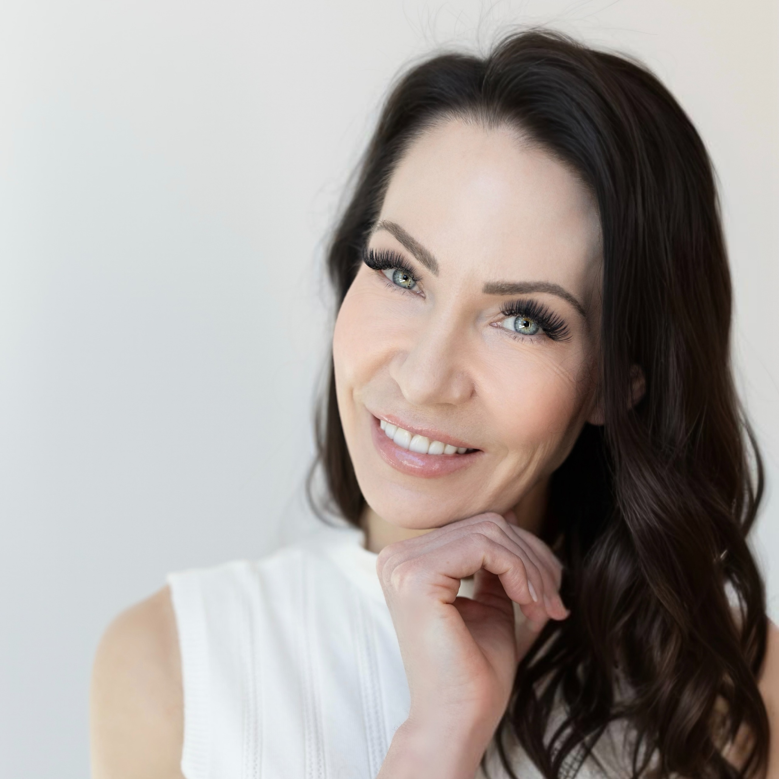 a white woman with dark brown hair in a white top