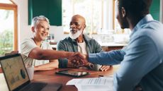 Cheerful older couple meeting a financial adviser in their home