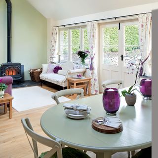 garden room with white wall fire place sofa grey dinning table and white door