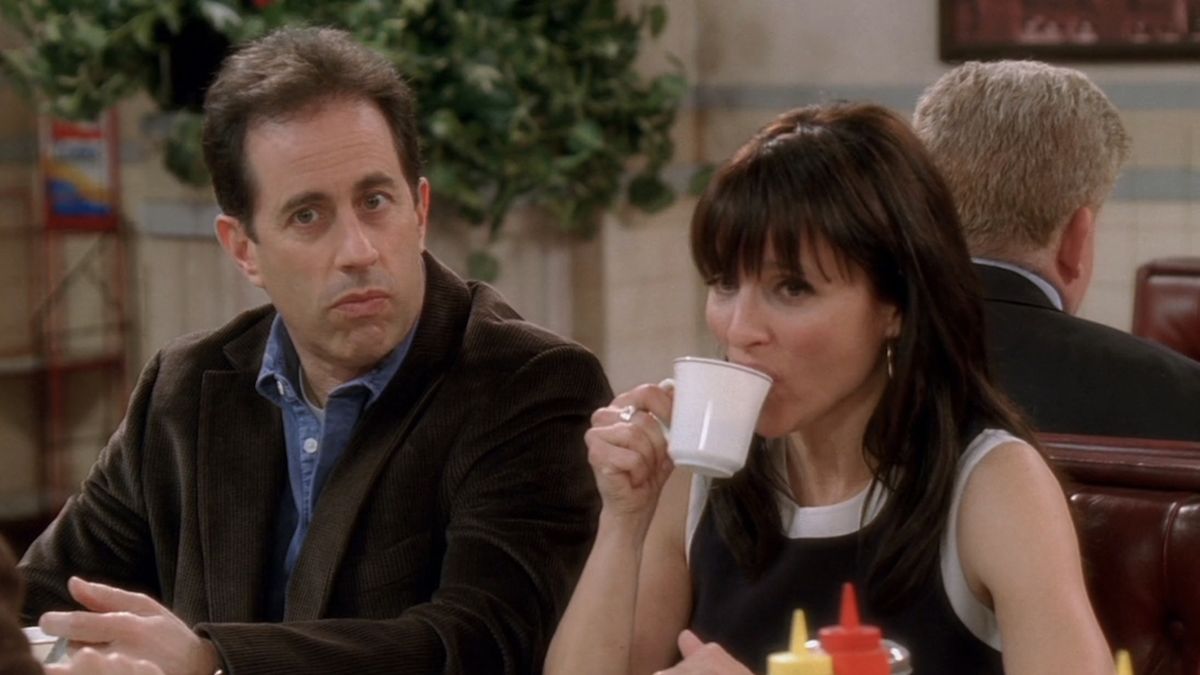 Jerry sitting next to Elaine, drinking a cup of coffee, at Monk&#039;s Diner in the Seinfeld reunion finale of Curb Your Enthusiasm