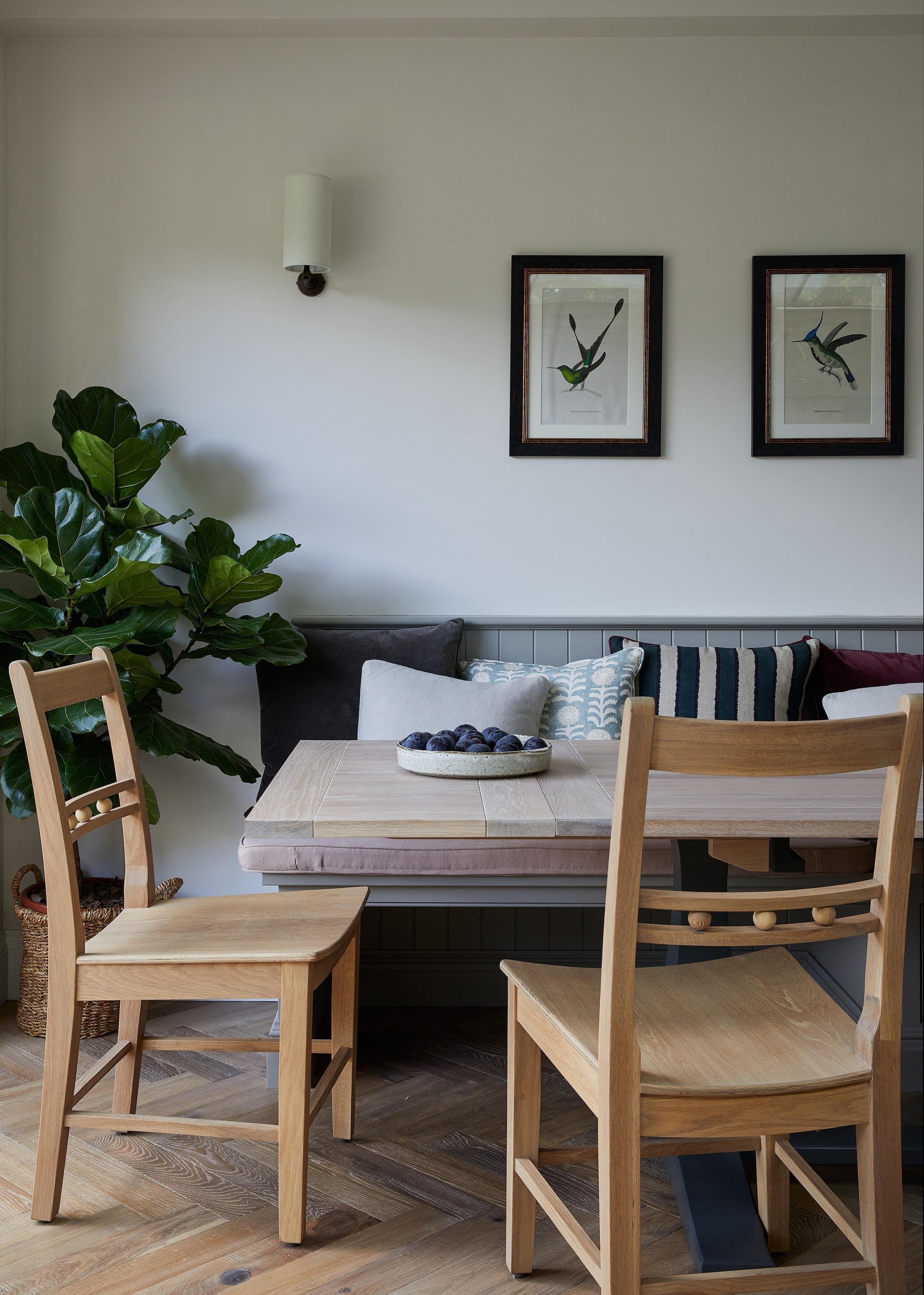 dining area with banquette seating painted grey and wooden dining chairs