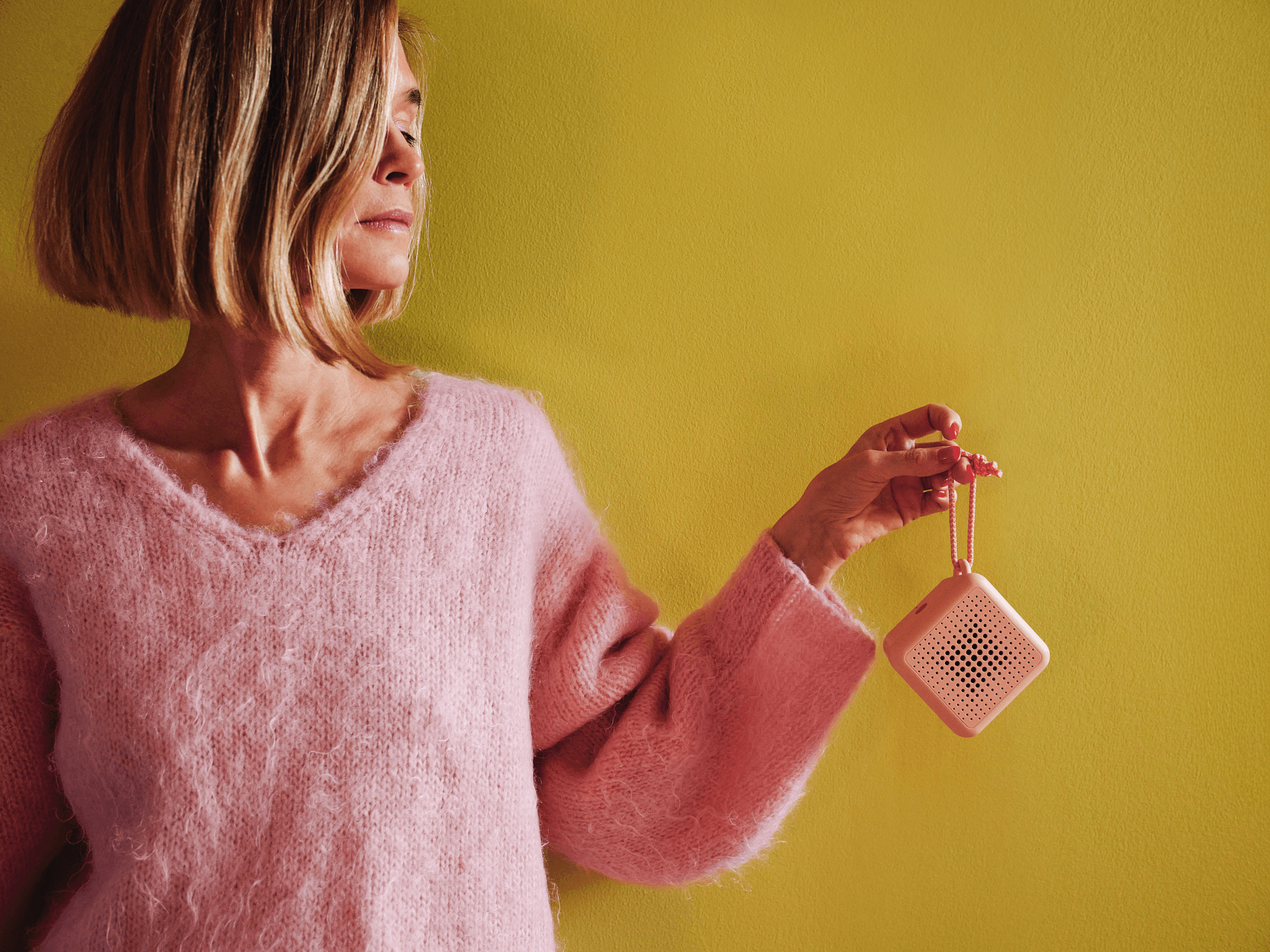 Swedish designer Teklan holding pink portable speaker