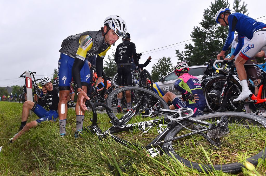 Race leader Fernando Gaviria (Etixx-QuickStep) tries to find his bike before abandoning the race