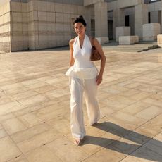 Bettina Looney wearing a white halter top and white pants