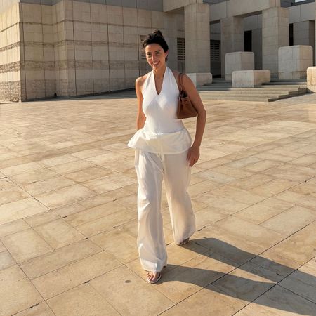 Bettina Looney wearing a white halter top and white pants