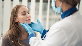 What Are Tonsil Stones? image shows doctor examining woman