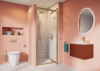 Pink bathroom with round illuminated mirror and shower stall with glass door