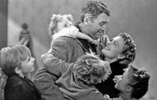 james stewart as George Bailey as he embraces his family in it's a wonderful life