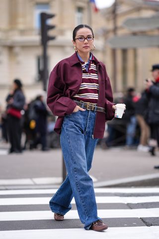 woman wearing striped long sleeve rugby shirt, jacket, jeans, and loafers