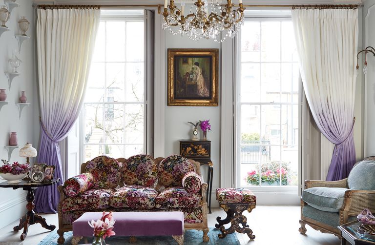 elegant living room with floral sofa, chandelier and sash windows 