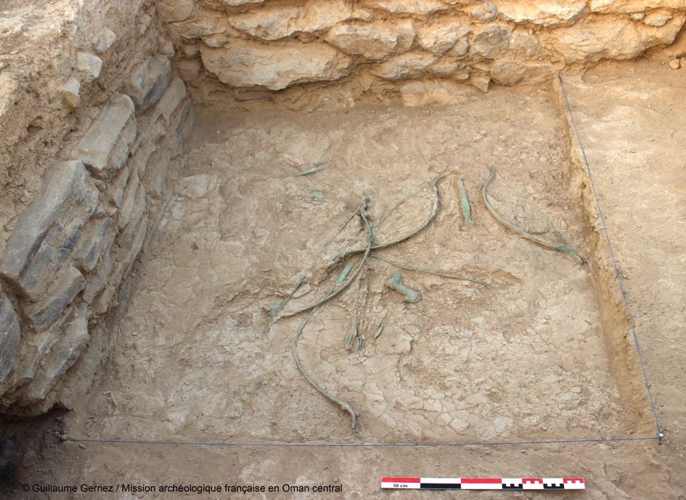 Bows, arrows, daggers and axes scattered on the ground at Mudhmar East, located on the coast of the Arabian Peninsula.