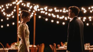 Dakota Johnson and Chris Evans stand across from each other in Materialists