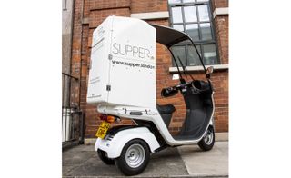 Japanese motorcycle that Supper delivery service uses, with a thermally lined, white box in the back.