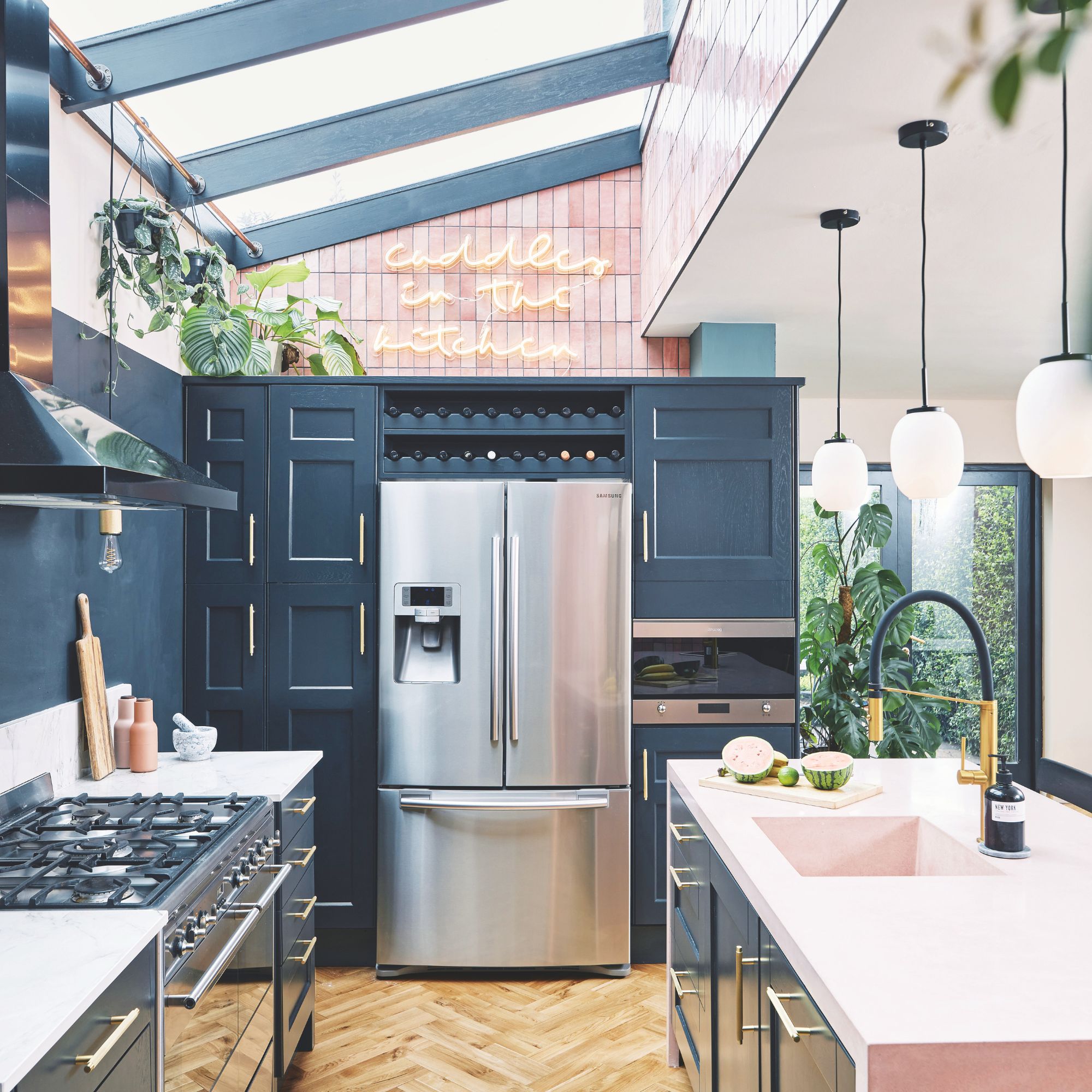 Kitchen with blue cabinets and a large fridge freezer, and a glass roof