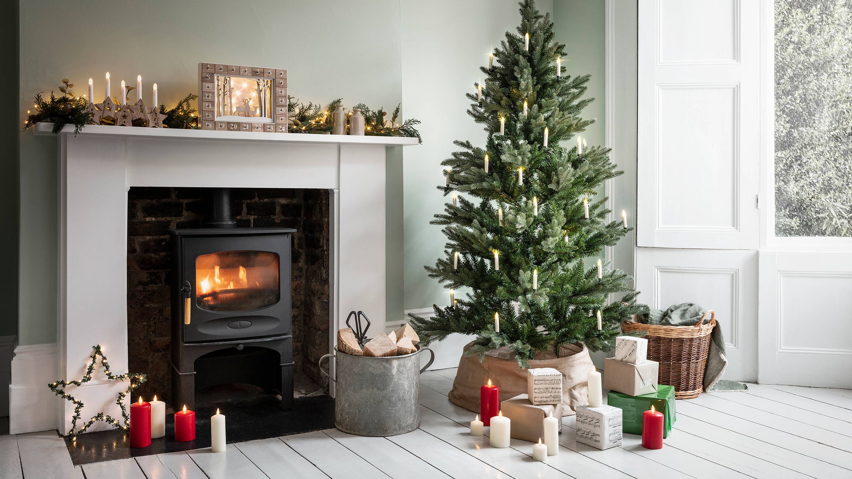 Kamin mit Ofen im Wohnzimmer mit weißen Dielen und Weihnachtsbaum