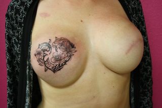 Nikki Black showing outline of floral tattoo on right scarred breast