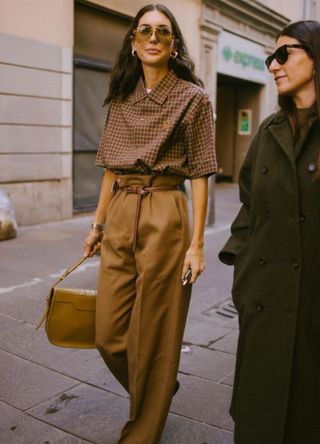 Woman in Milan wearing tan trousers and a checked brown shirt