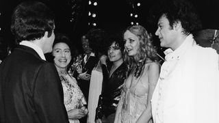 British talk show host Russell Harty (1934 - 1988) (right), introduces Princess Margaret (1930 - 2002) to some British entertainment stars including (left to right) singer Marc Bolan of T-Rex (1947 - 1977), model and actress Twiggy, and sweating performer Gary Glitter, at a charity concert in Drury Lane, London, December 20, 1976.