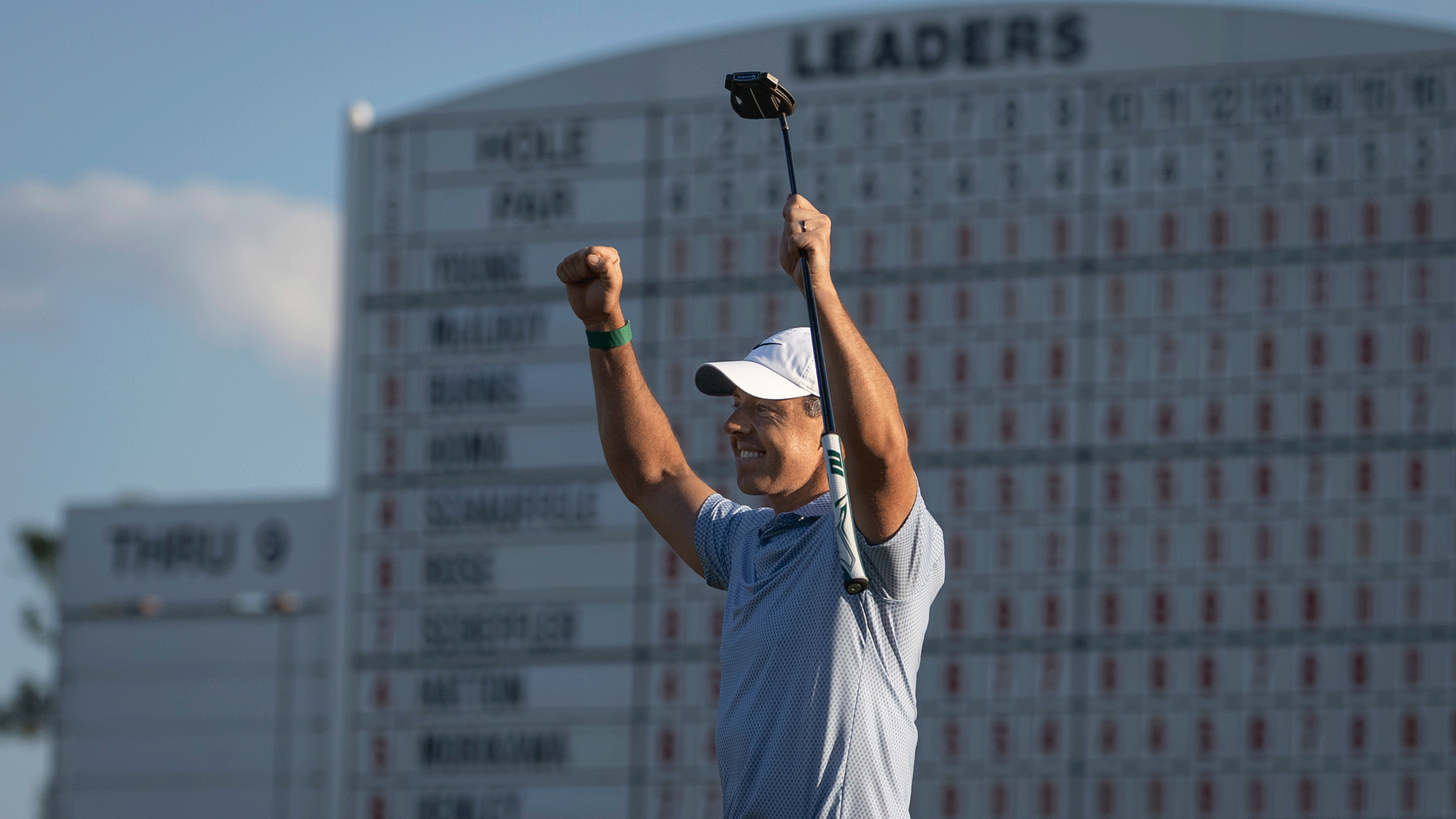 Rory McIlroy puts both fists up in the air while holding his putter after winning The Masters in 2026