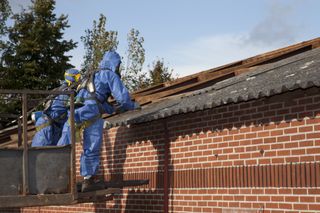 asbestos roof tiles being removed by professionals in PPE equipment