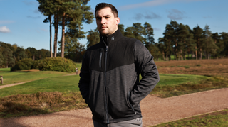 A golfer poses in the FootJoy ThermoSeries Hybrid Jacket