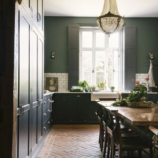 kitchen with dark green cabinets and dining table