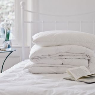 room with white wall and white cushion on white bed