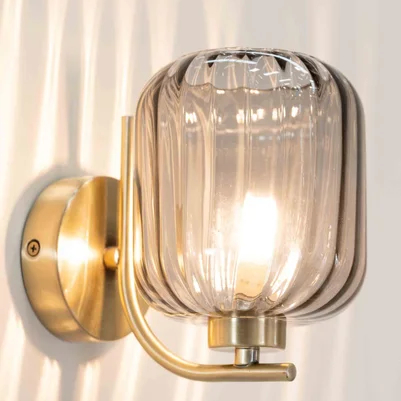 wall light with smoked glass ribbed shade and brushed gold fitting