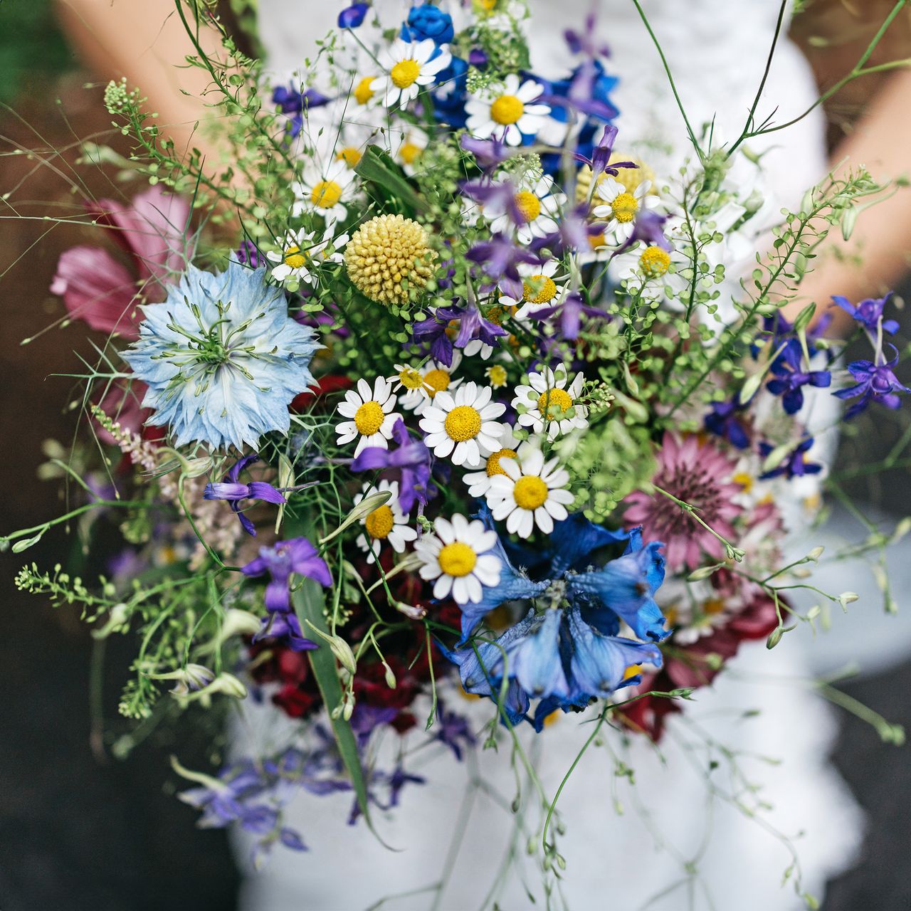 Bride holds bouquet of wildflowers at her wedding