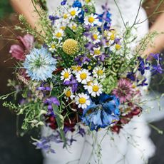 Bride holds bouquet of wildflowers at her wedding
