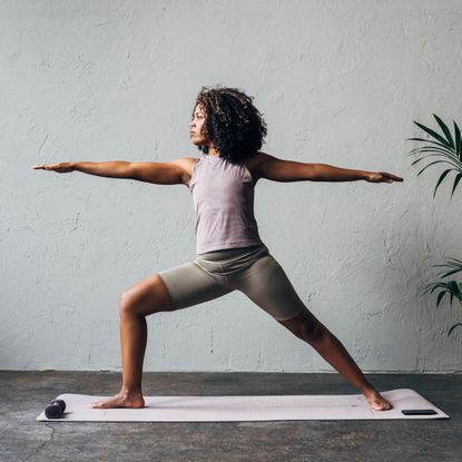 A woman doing one of the best yoga flows for core strength: at home, on her yoga mat