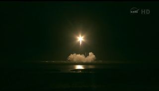 SpaceX Falcon 9 rocket soars into the predawn sky above Florida carrying the unmanned Dragon capsule.