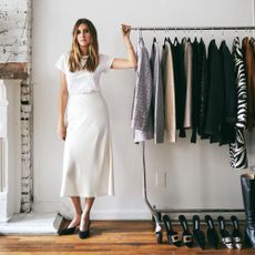 Allison Bornstein stands next to a rail of clothes.