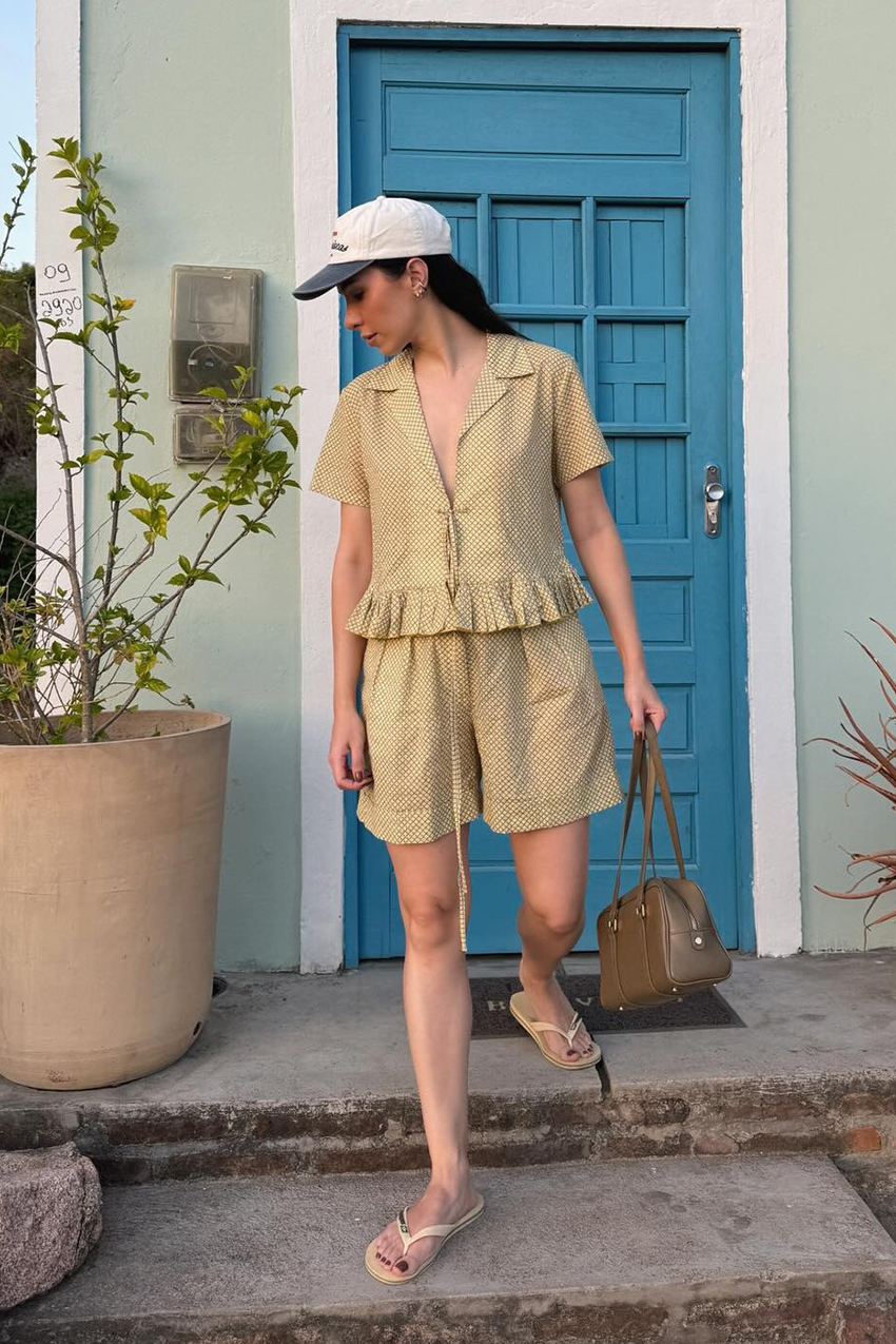 a woman wearing a baseball cap and a checkered matching set with flip flops
