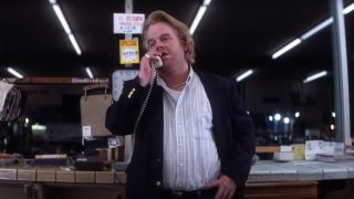 Phillip Seymour Hoffman stands impatiently as he takes a phone call in Punch-Drunk Love.