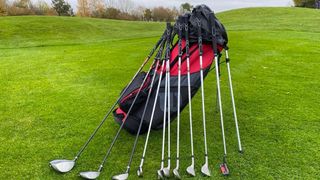 Wilson Prostaff SGI Package Set resting on the green showing off its red and black club bag