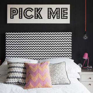 bedroom with black walls and black and white headboard