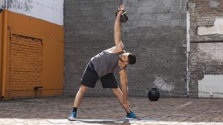 Man doing kettlebell windmills to exercise abs