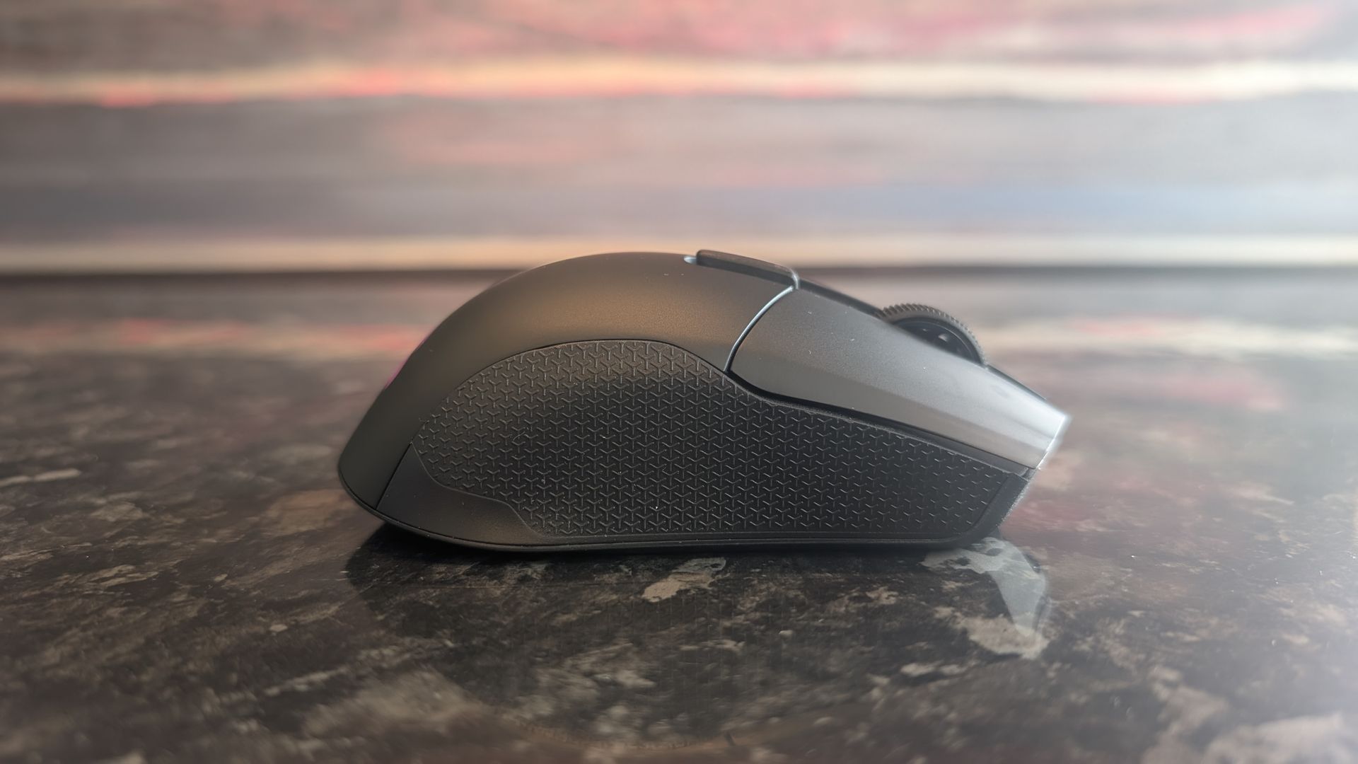 The Corsair Harpoon V2 Wireless gaming mouse pictured on a dark marble worktop.