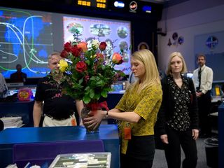 MacKenzie Shelton (center) sets down a bouquet of flowers in mission control in 2009.