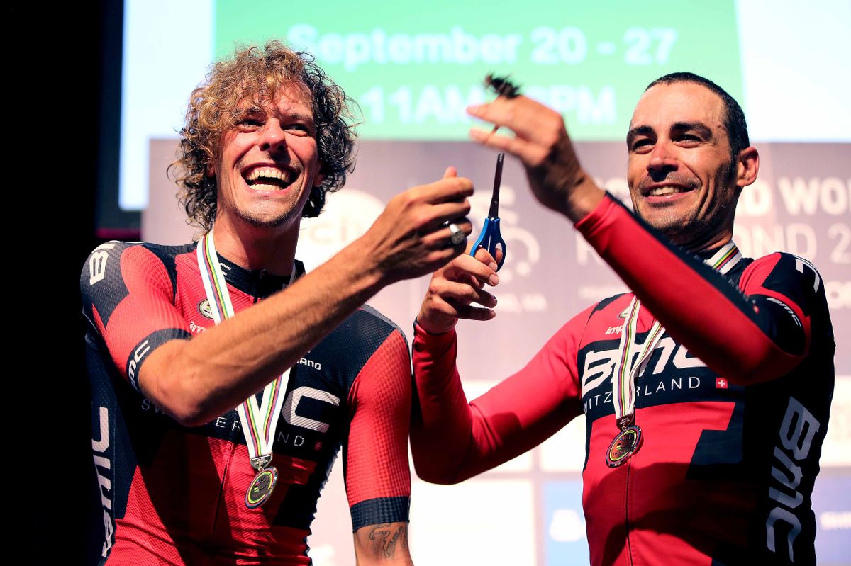 Manuel Quinziato holds aloft the lock of hair he cut from Daniel Oss